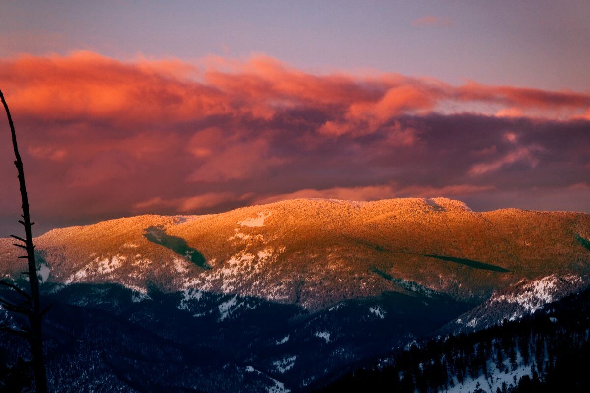 A picturesque sunset over a snowy mountain range in Montana.