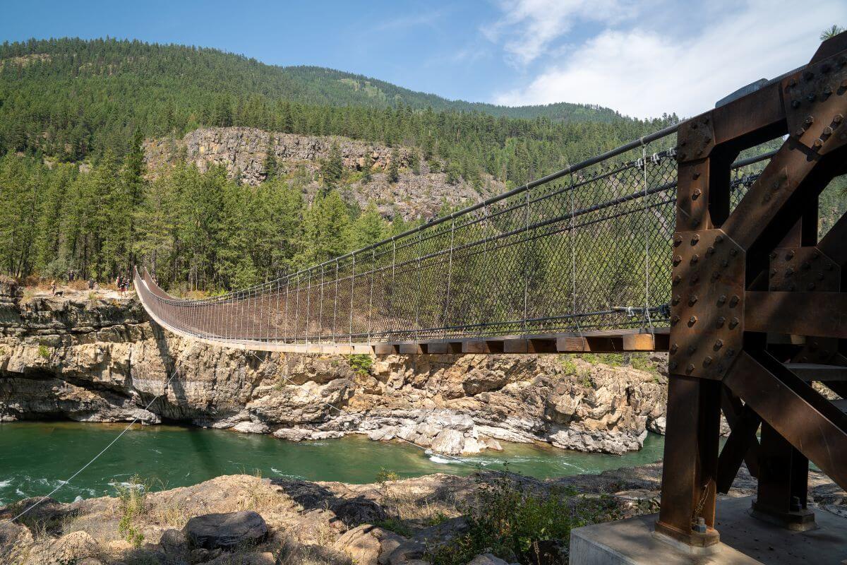 The Kootenai Falls suspension bridge spans over the relatively calm Kootenai River in Montana.





