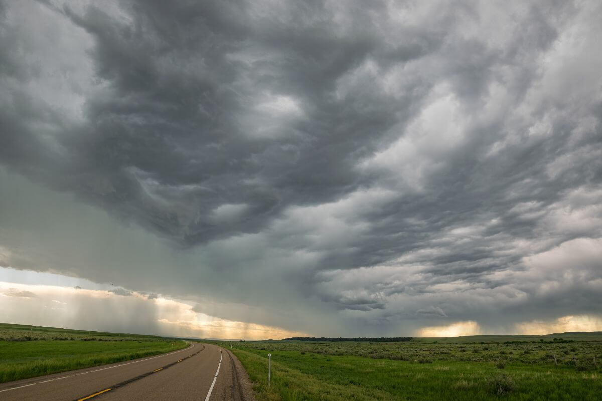 Storm clouds over a road in the middle of a prairie in Montana.