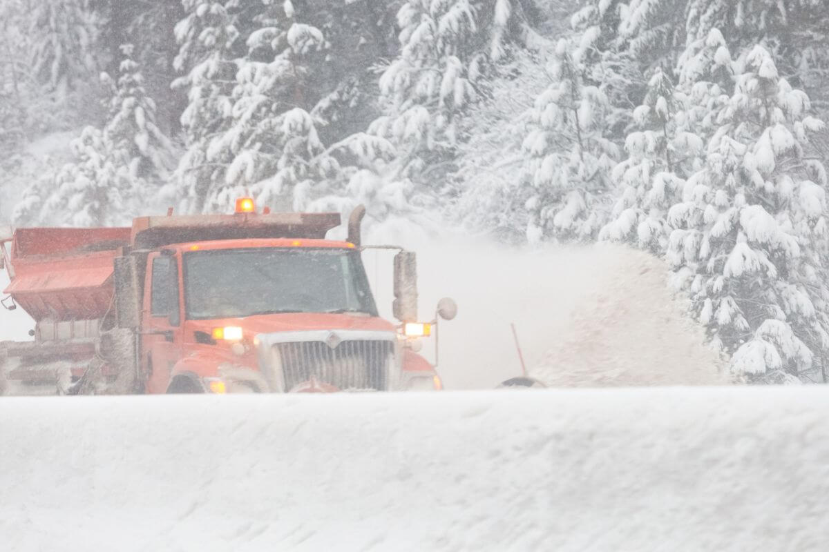 A snowplow driving down a road in Montana.