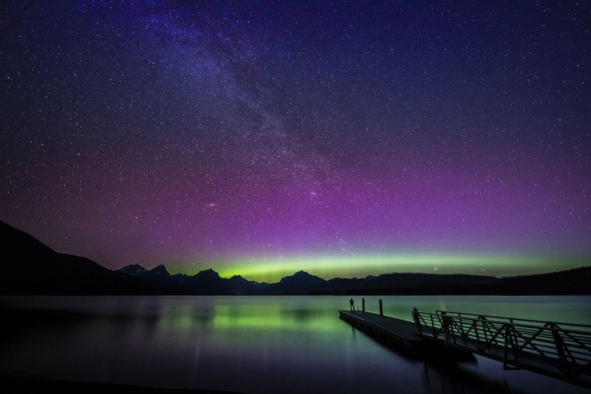 A picturesque lake dock in Montana under a captivating aurora borealis