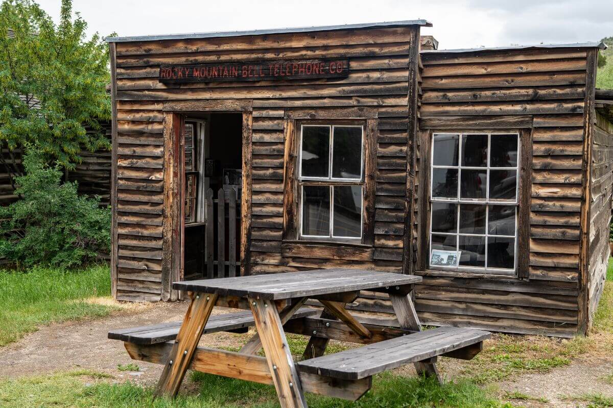 A wooden building in Montana with a picnic table in front.
