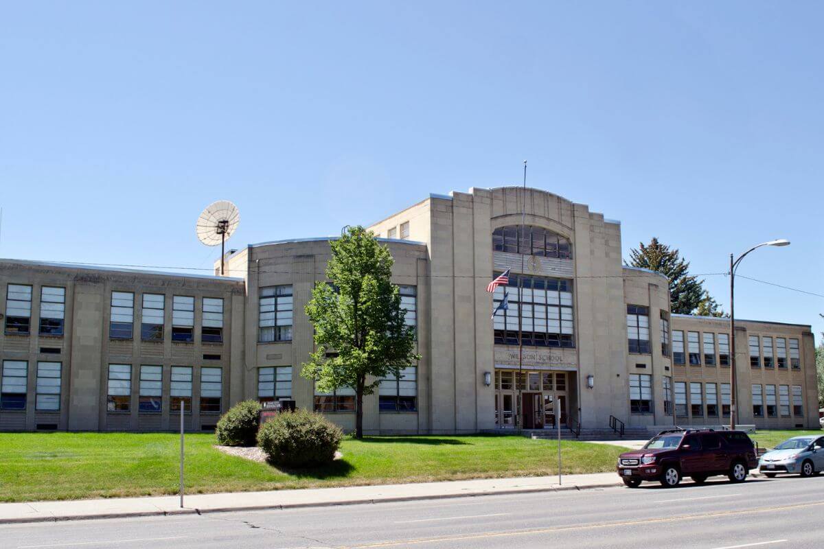 A large school building with cars parked in front of it located in Montana