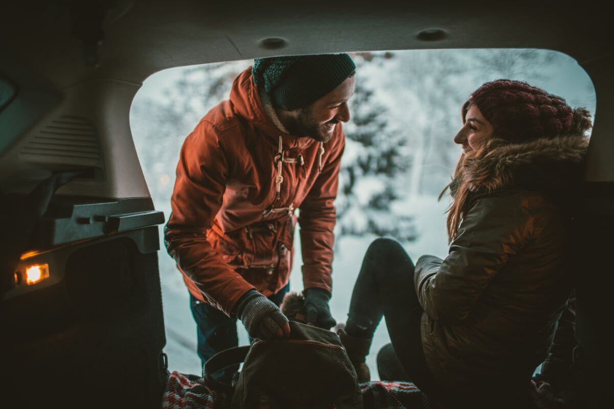 A man and woman prepare to get out of their car and enjoy their romantic winter getaway in Montana.