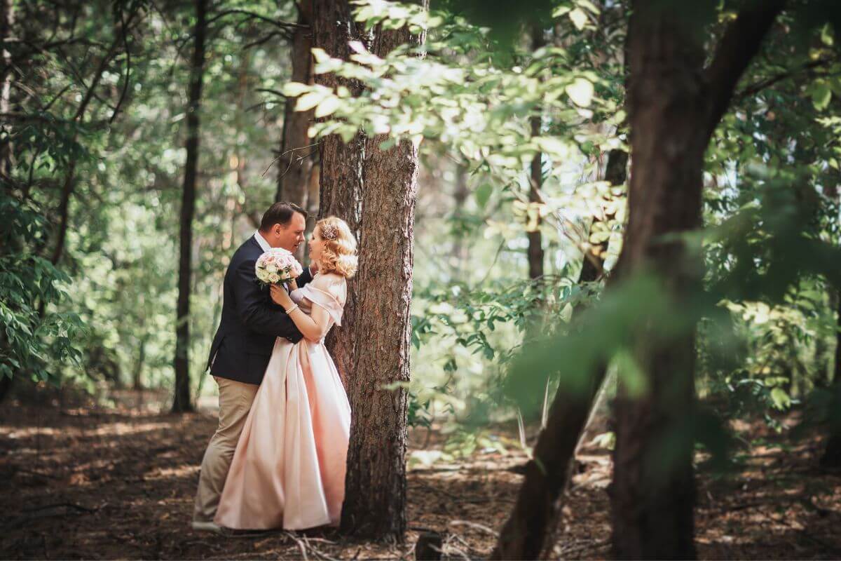 A newly married couple is about to share a sweet kiss in the enchanting woods of Montana.