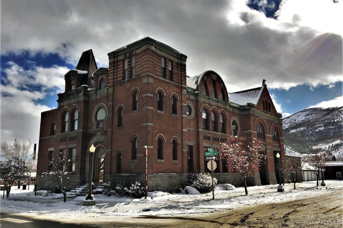 A red brick building in Montana with lots of snow on the ground.