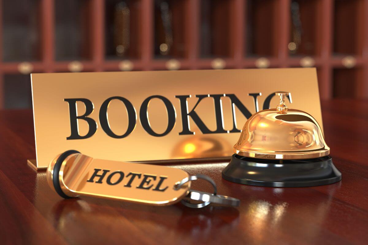 A wooden table showcases a sign and a bell for booking a hotel in Montana.