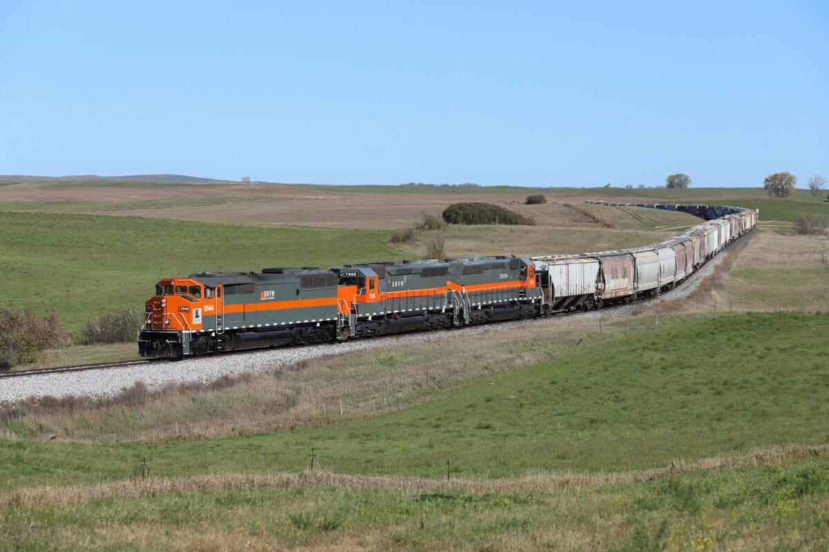 A train traveling down a track amid the scenic beauty of a grassy field in Montana.