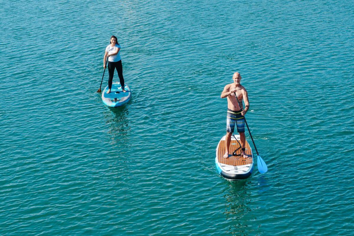 Two people enjoy paddle boarding activities in Montana's waters.