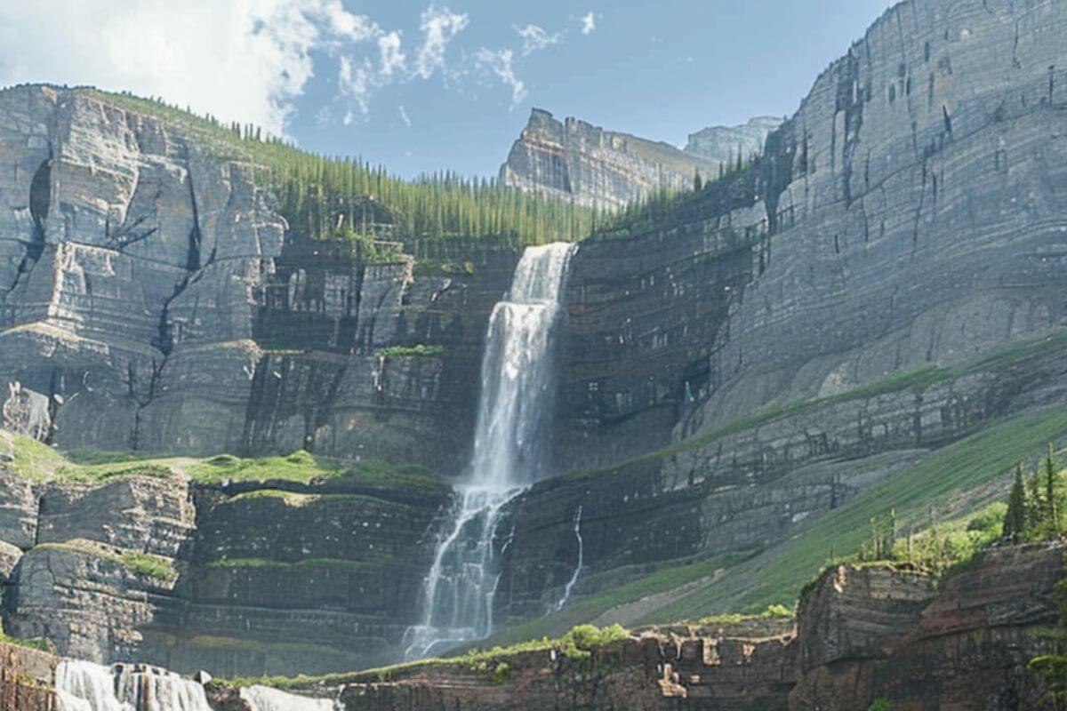 A view of the series of cascades that form Hole-in-the-Wall Falls within high cliffs of Glacier National Park