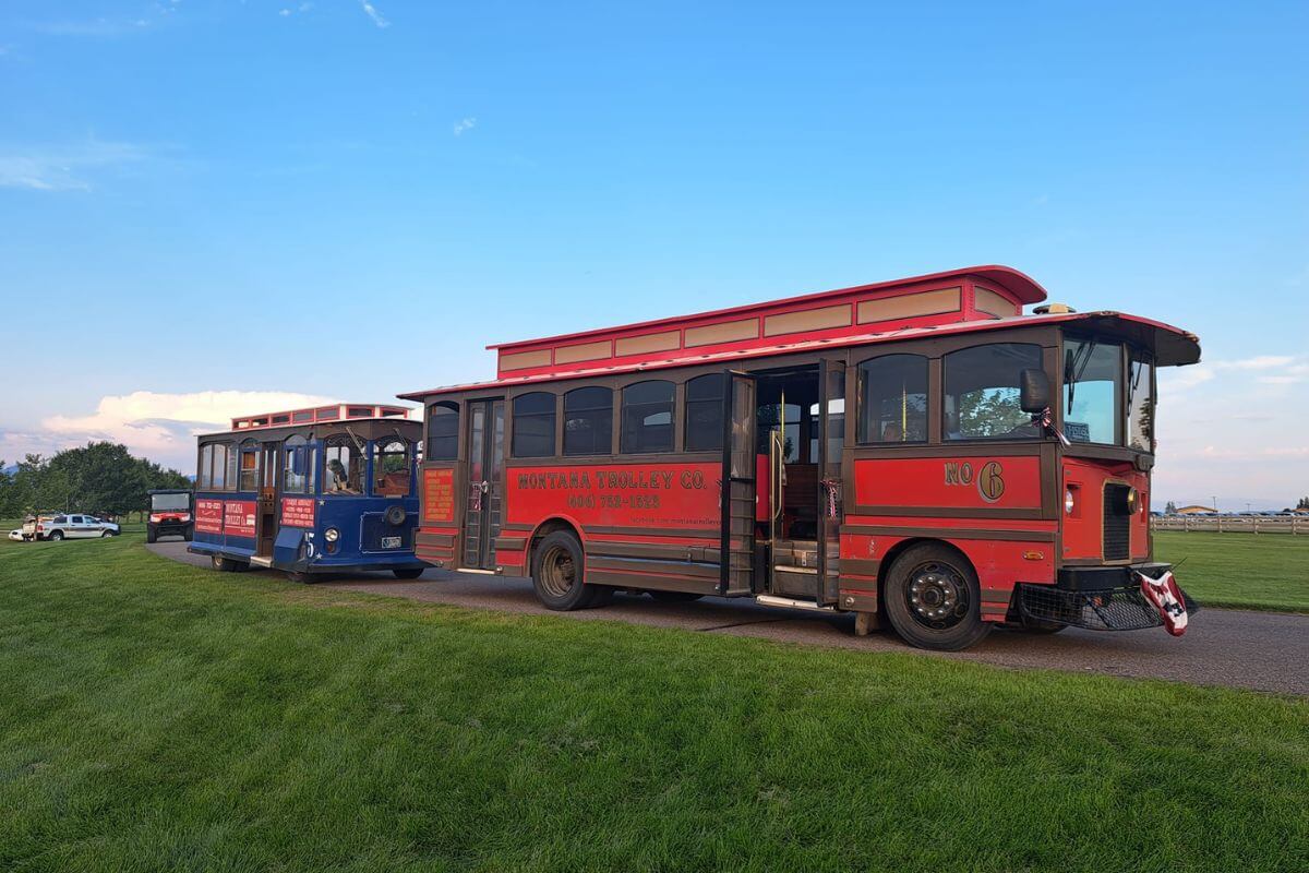 Vintage-style trolley buses from Montana Trolley Company await passengers for bus tours.