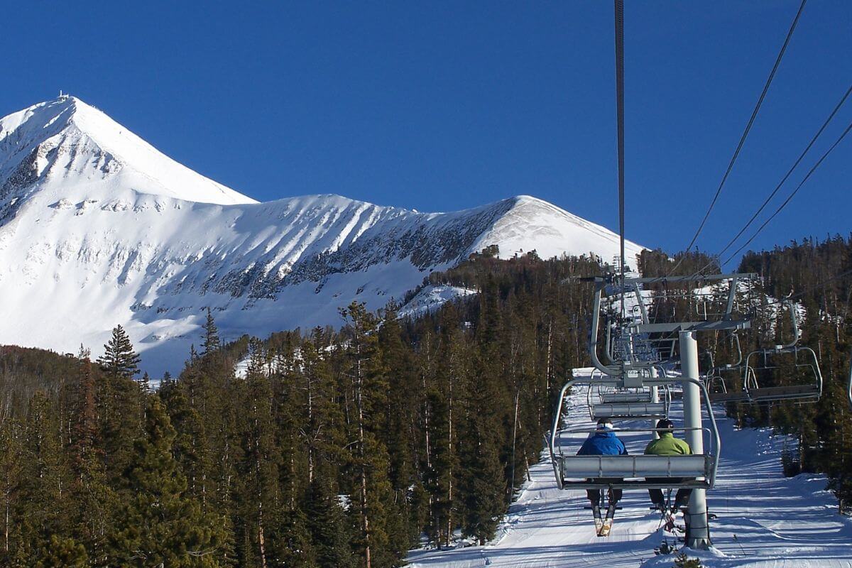 A ski lift ascending a snow-covered mountain
