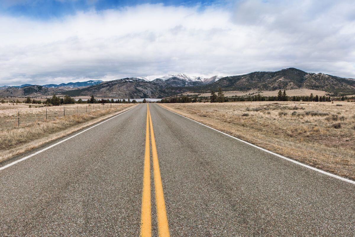An empty road with Montana mountains in the background.