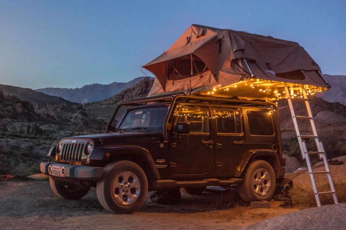 An off-road Jeep equipped with a rooftop tent parked in rugged terrain during Yellowstone Tracks' jeep tour.