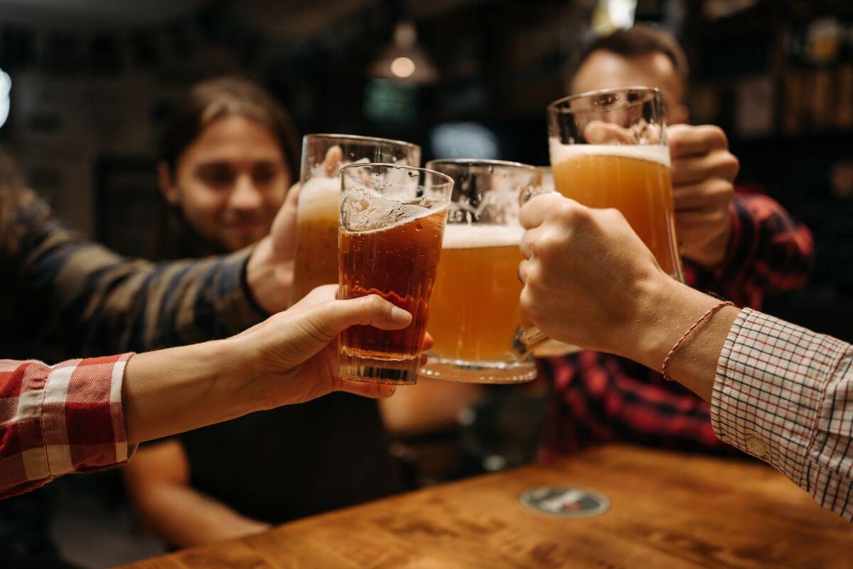 A group of people toasting beer at a bar in Montana during fall season.