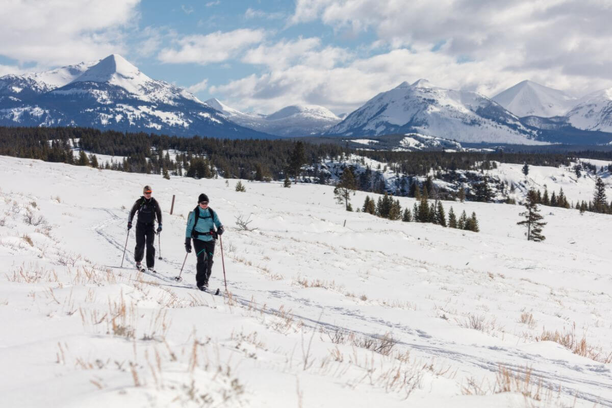 Two people enjoying cross-country skiing in a snowy slope in Montana.