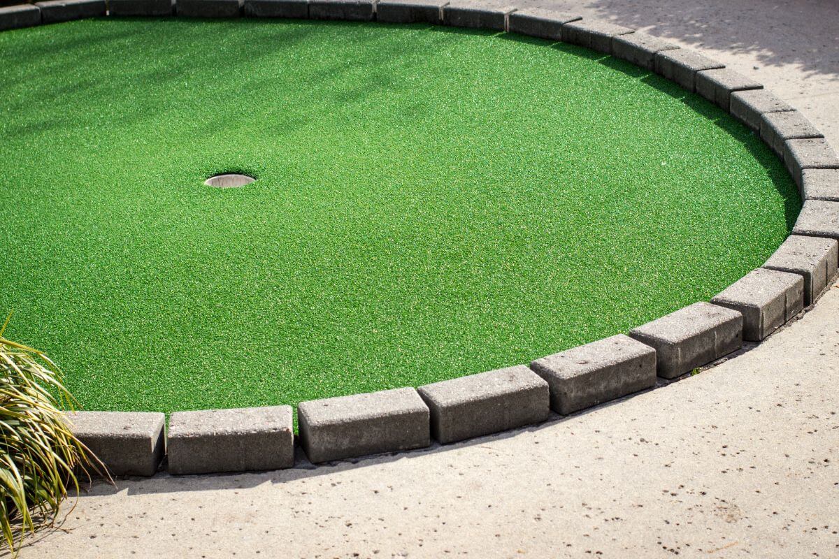 The hole end of a top mini golf course in Montana is shaped with grey bricks.