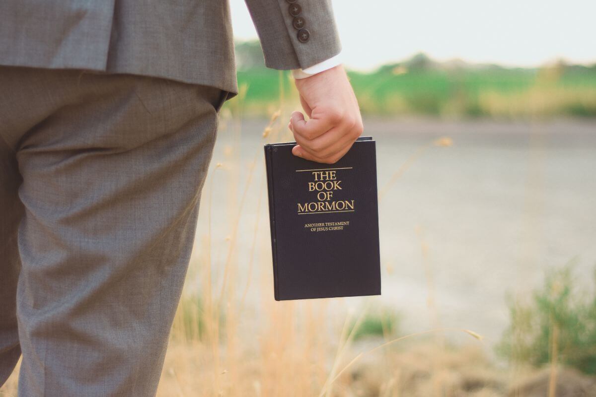 A man in a suit holding the book of Mormon in Montana.