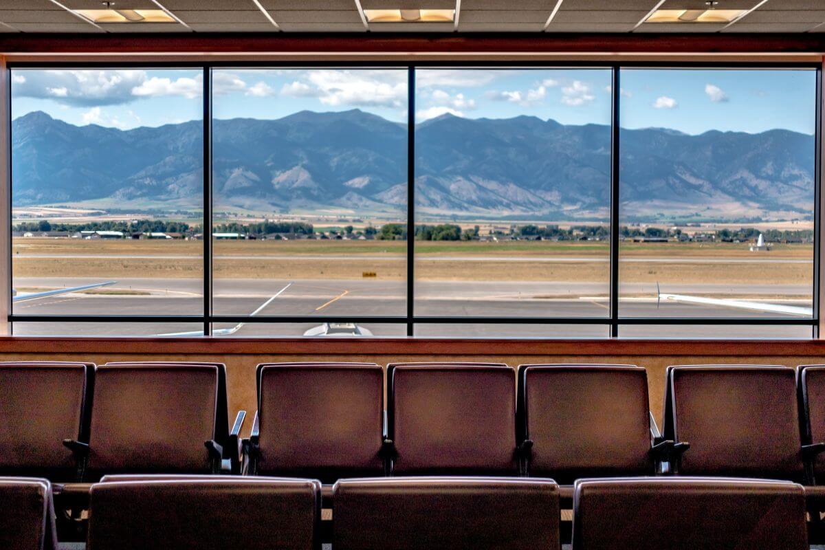An airport waiting room in Montana with a scenic view of mountains.