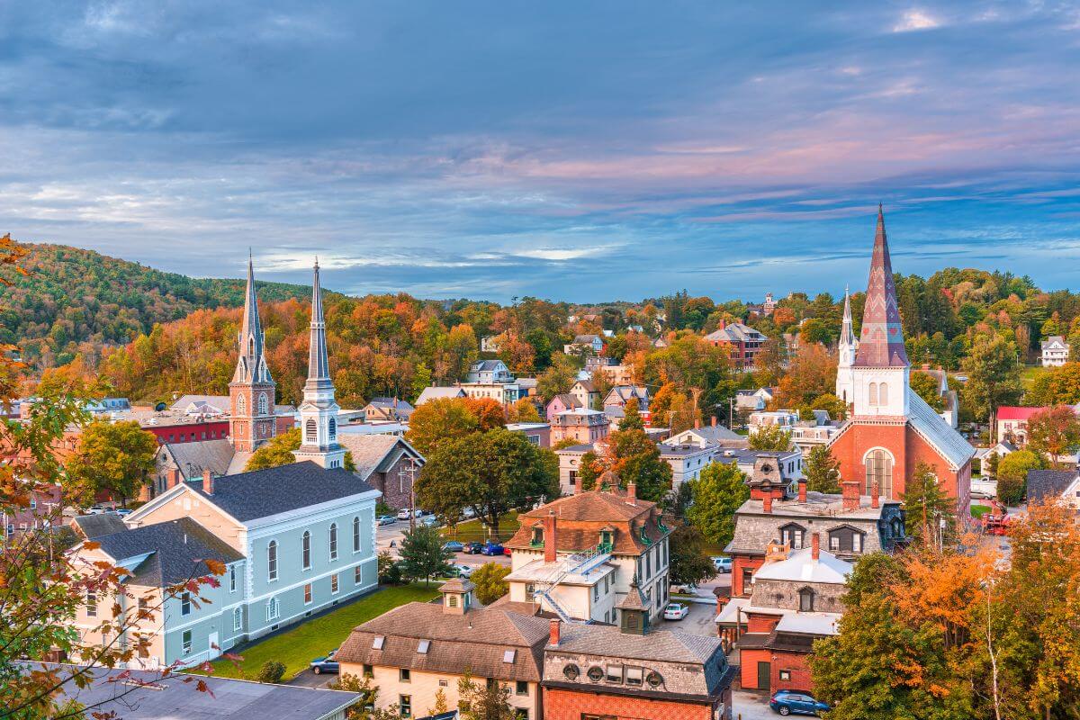 An aerial view of a town in Vermont during the fall, with churches and houses on display.