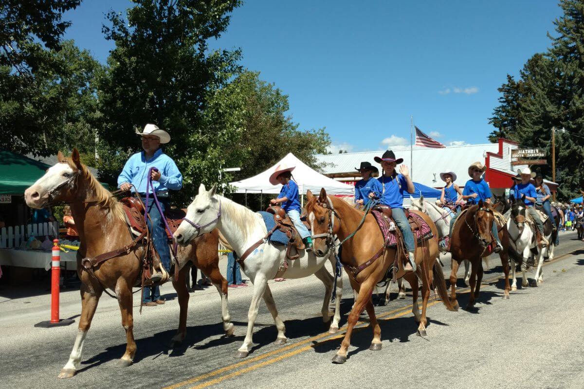 A group of people in Montana take part in a lively parade riding horses.