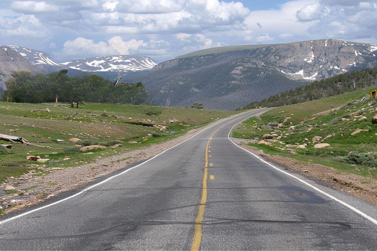 The scenic Beartooth Highway winding through the mountains, with majestic peaks in the distance.