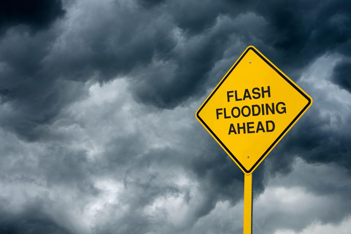 Flash flooding ahead sign in front of a cloudy sky in Montana.