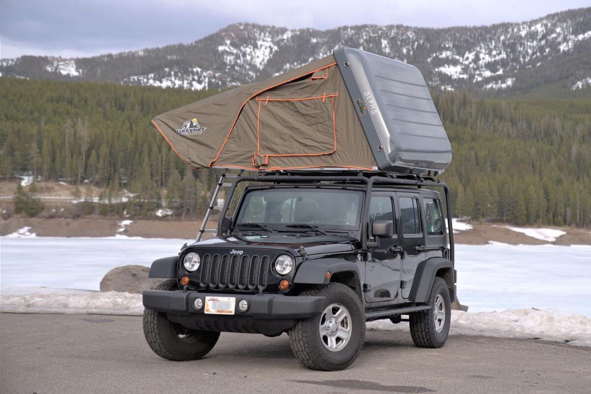 A Jeep with a rooftop tent parked in a mountainous area during a Montana Overlanding's jeep tour.