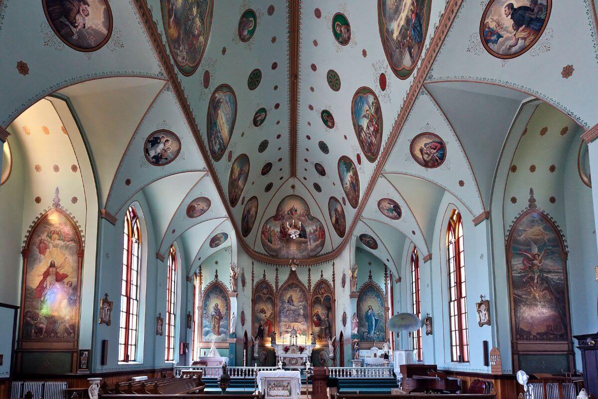 Inside St. Ignatius Mission Church in Montana adorned with paintings on its walls and ceiling.
