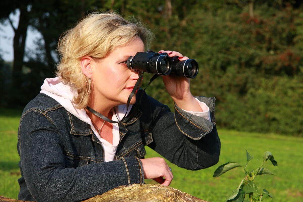 A woman observes wildlife in Montana using her binoculars.