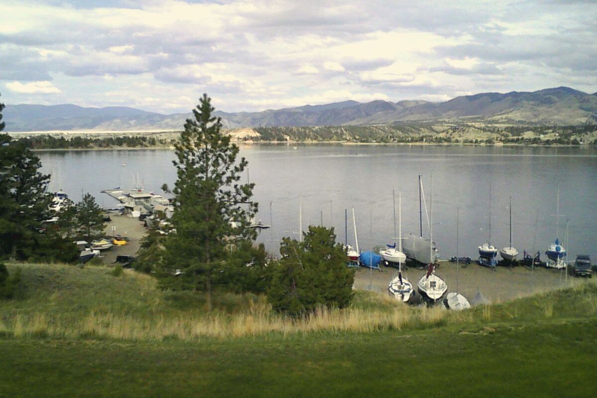 One of the most expensive homes in Montana, featuring a boat docked on a gorgeous lake surrounded by majestic mountains.