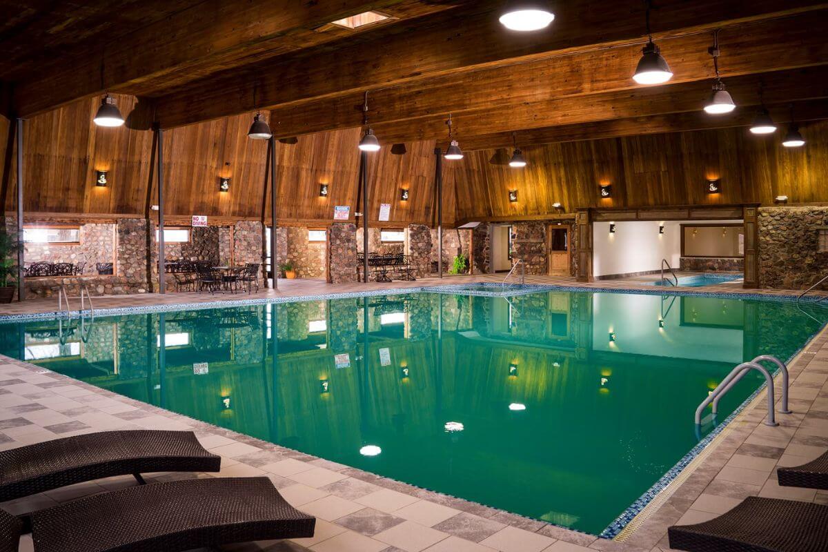 A large indoor swimming pool with lounge chairs in Sleeping Buffalo Hot Springs and Resort.