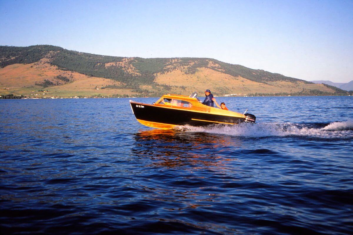 An ideal setting for a wonderful Montana vacation, a yellow and black boat navigates through deep blue waters.