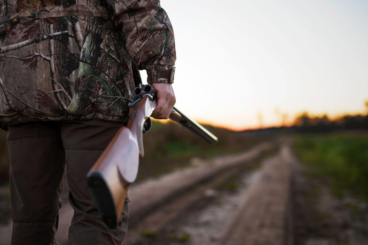 A hunter carries his rifle as he looks ahead at the path to his hunting spot in Montana.