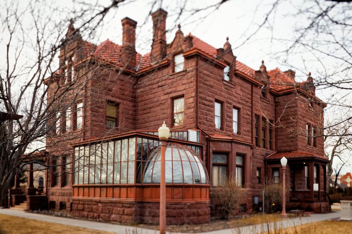 One of the most expensive homes in Montana, a red brick house with a gable roof.