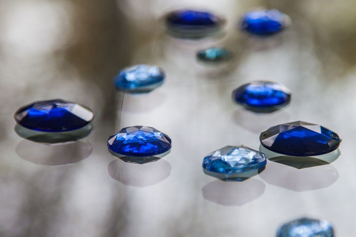 Blue sapphires, Montana's gemstones, glisten on a glass surface.