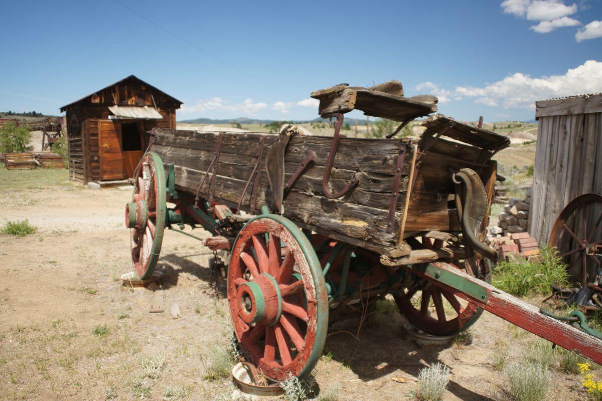 An old wooden wagon sits in a dirt field at the World Museum of Mining, Montana.