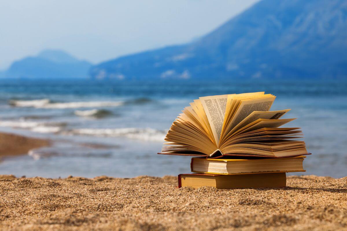 3 books on top of one another on the sand by the beach in Montana