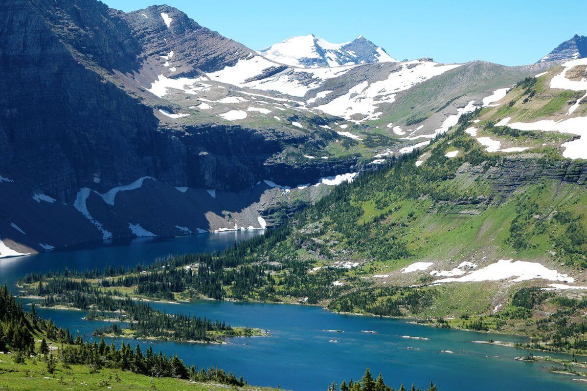 Snow-capped mountains overlooking a lake as seen in Glacier National Park