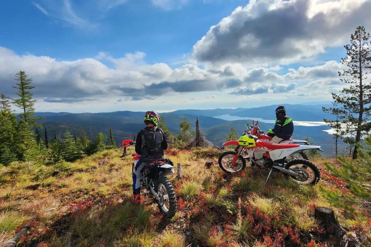 Riders on dirt bikes pause to admire a cliffside view during their tour operated by Flathead Outdoors.