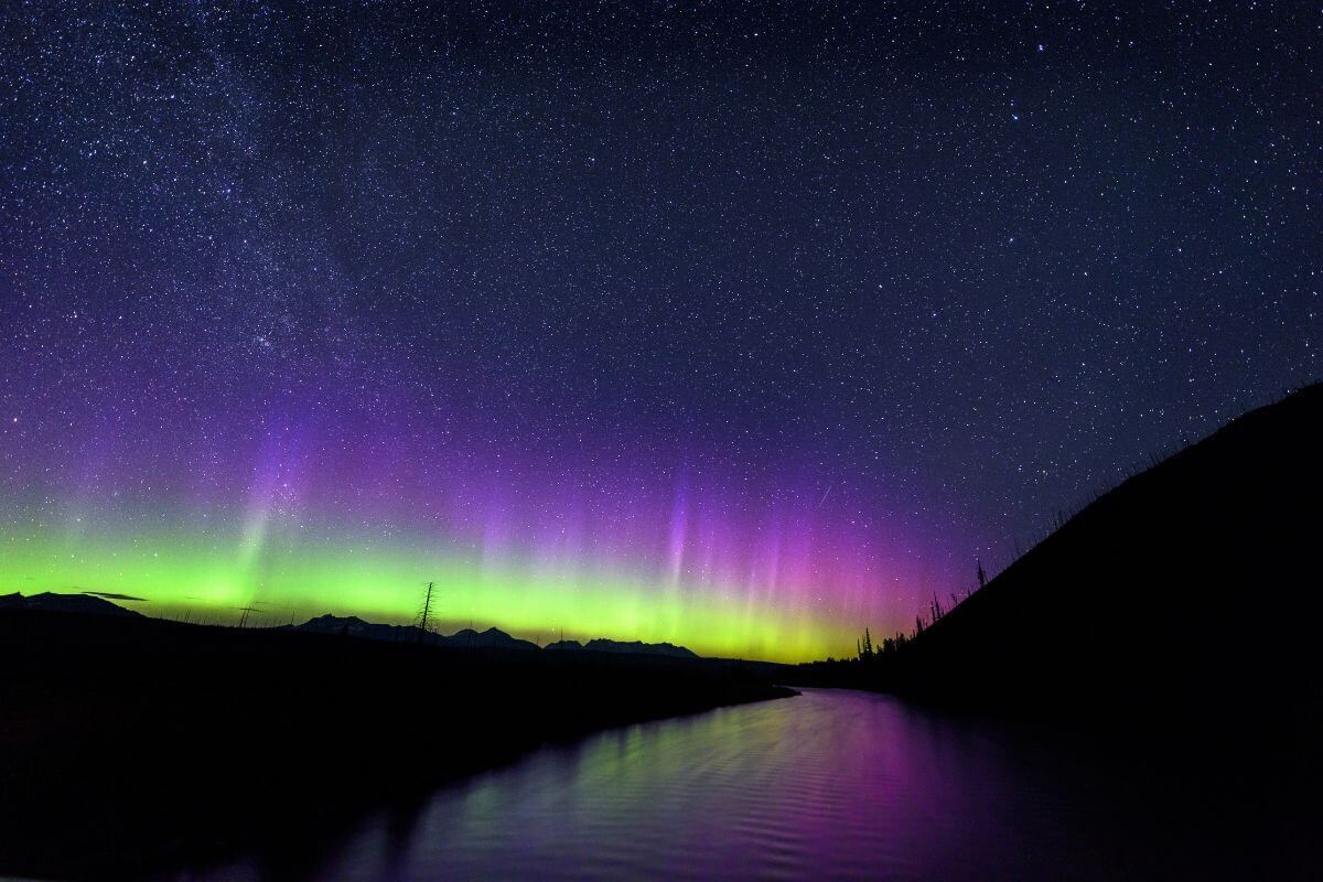 Green and purple Northern Lights dance over Glacier National Park in Montana.