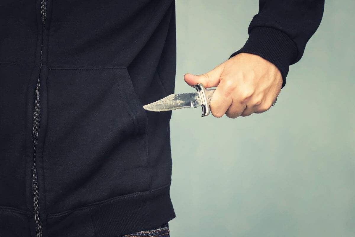 Man Pulling Out a Folding Pocket Knife