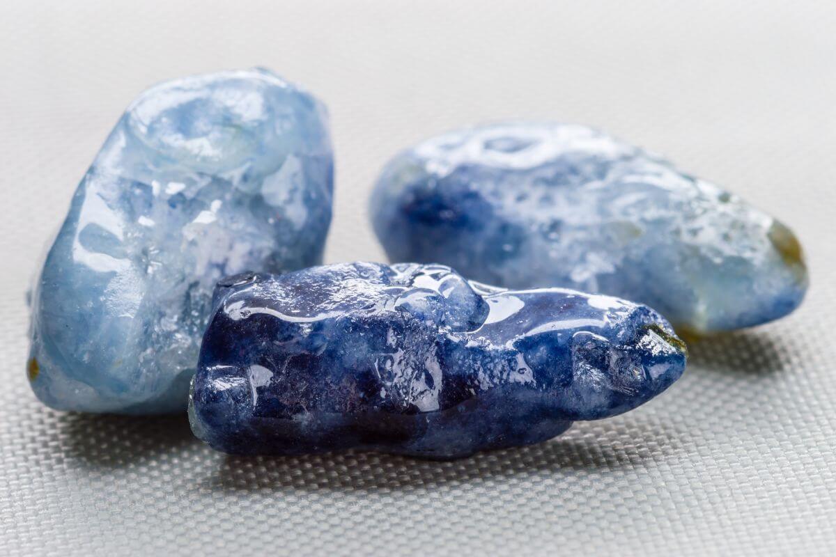 Three pieces of blue Yogo Sapphire on a surface.
