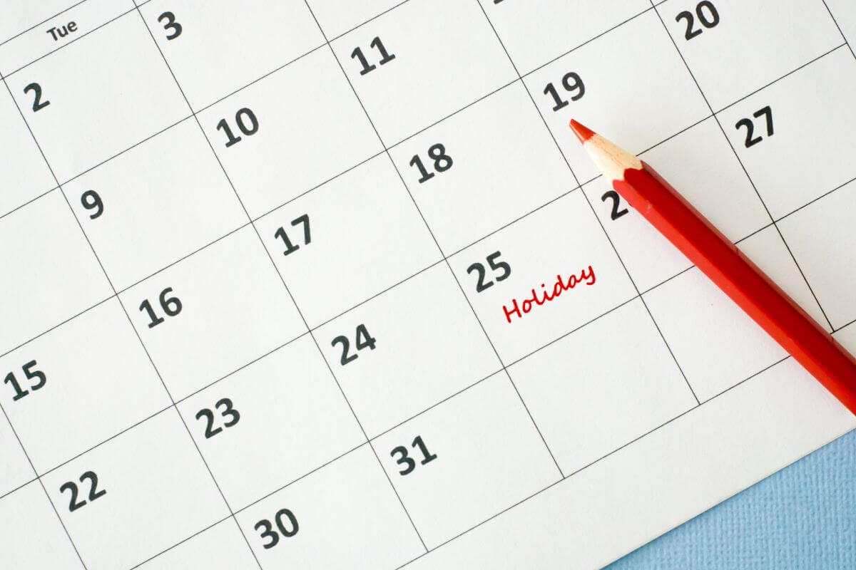 A red pencil sits on a calendar.