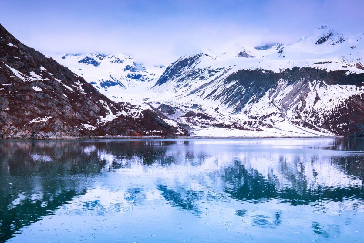An icy lake nestled amid snow-capped mountains in Alaska, the coldest state in the U.S.