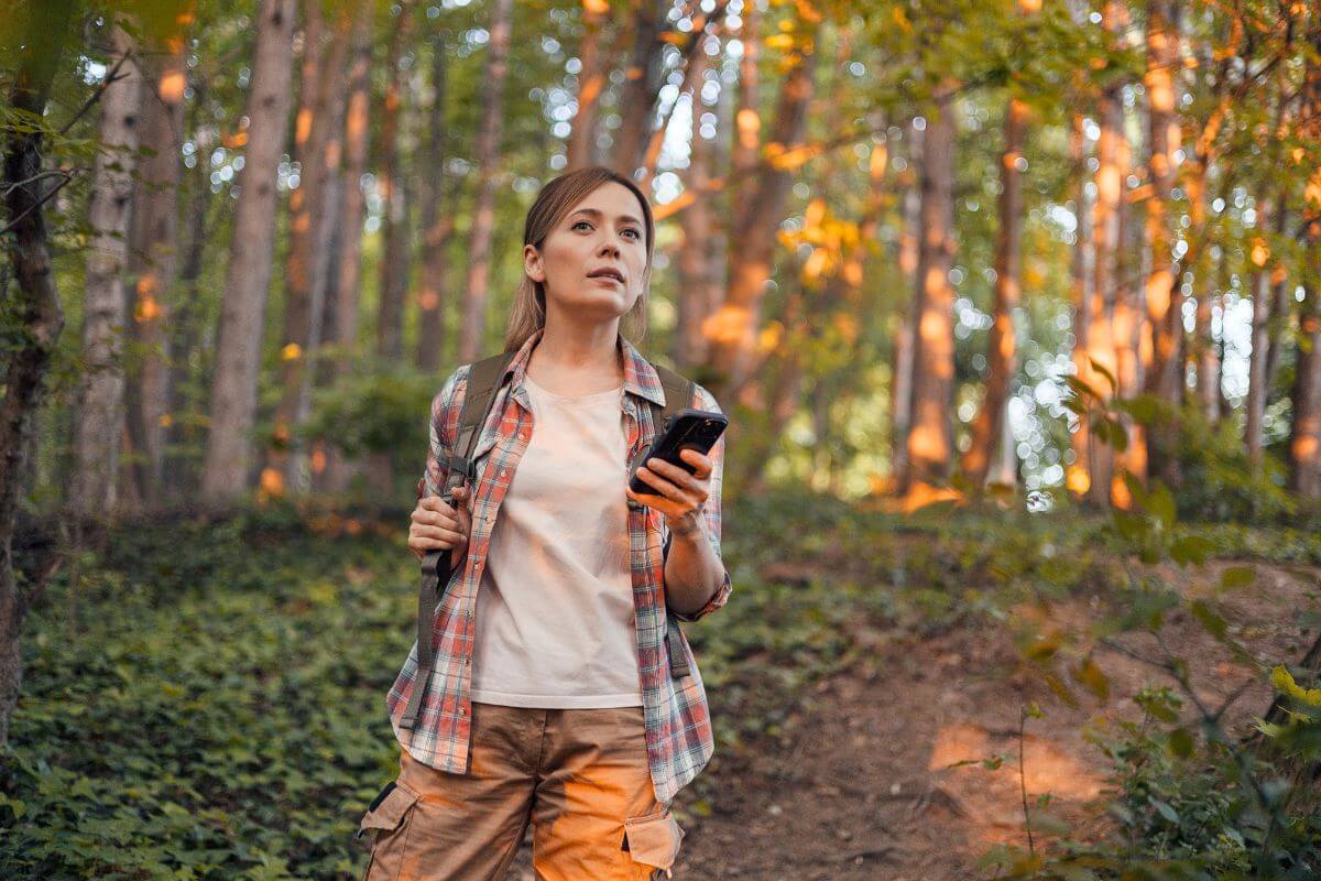 A hiker on a trail to Paradise Falls checks her GPS locator to find out her location