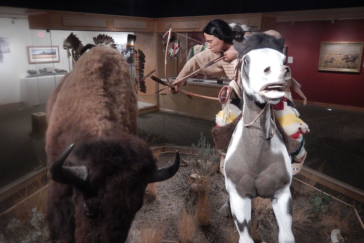 A large figurine of bison and a man on a horse in a museum in Montana.