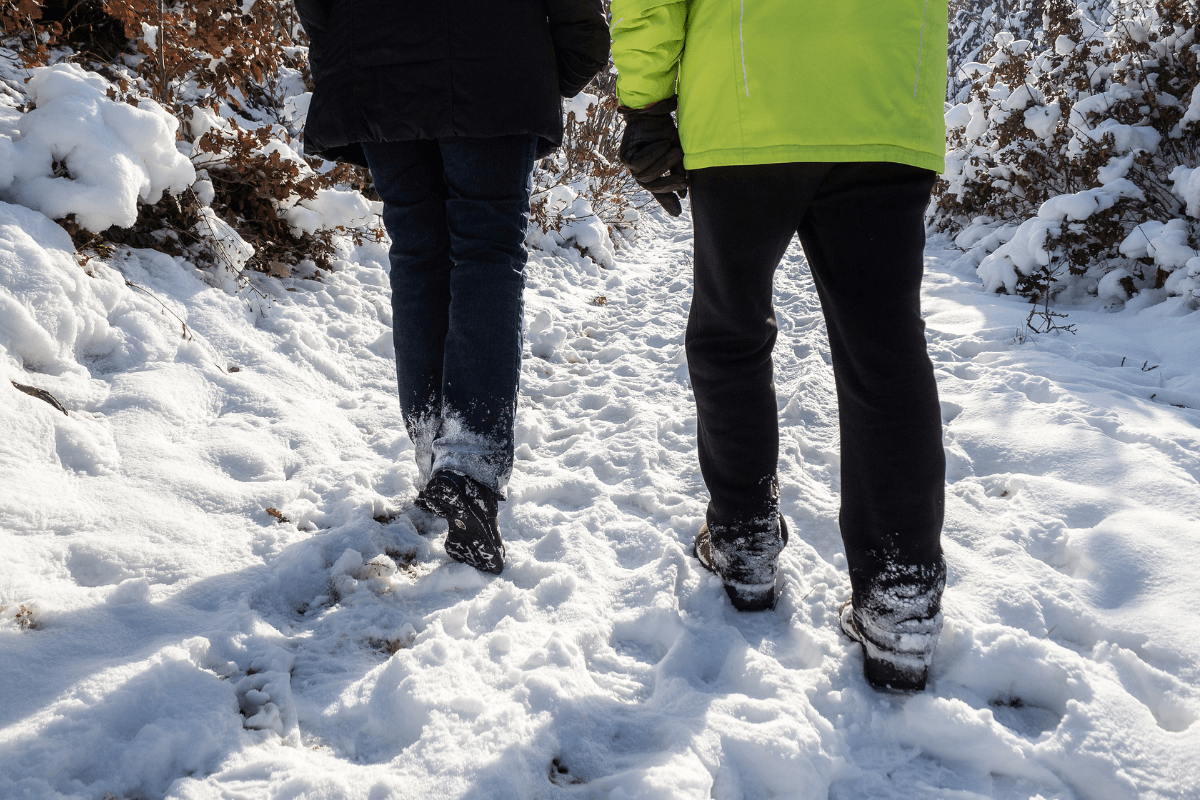 Two people braving the snowy terrain of Montana, equipped with winter boots.