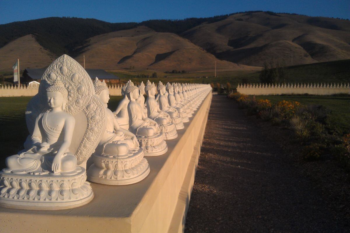 A line of white Buddha statues at the Garden of One Thousand Buddhas, Montana.