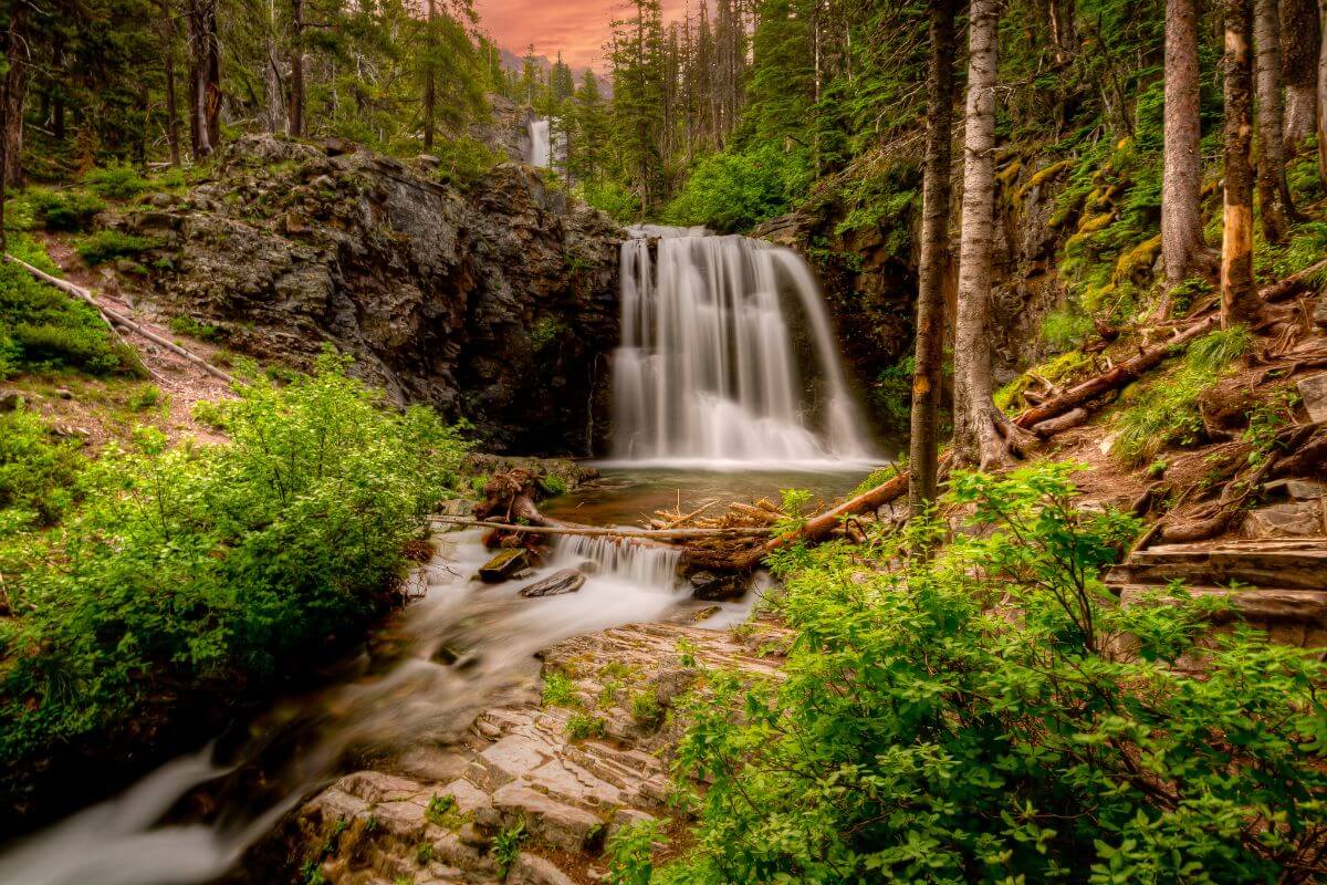 A stunning view of a Montana waterfall during the golden hour.
